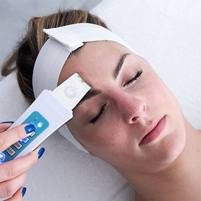 Ultrasonic skin scrubber treatment with skin spatula for female client at Face of Jules Los Angeles Facial Spa